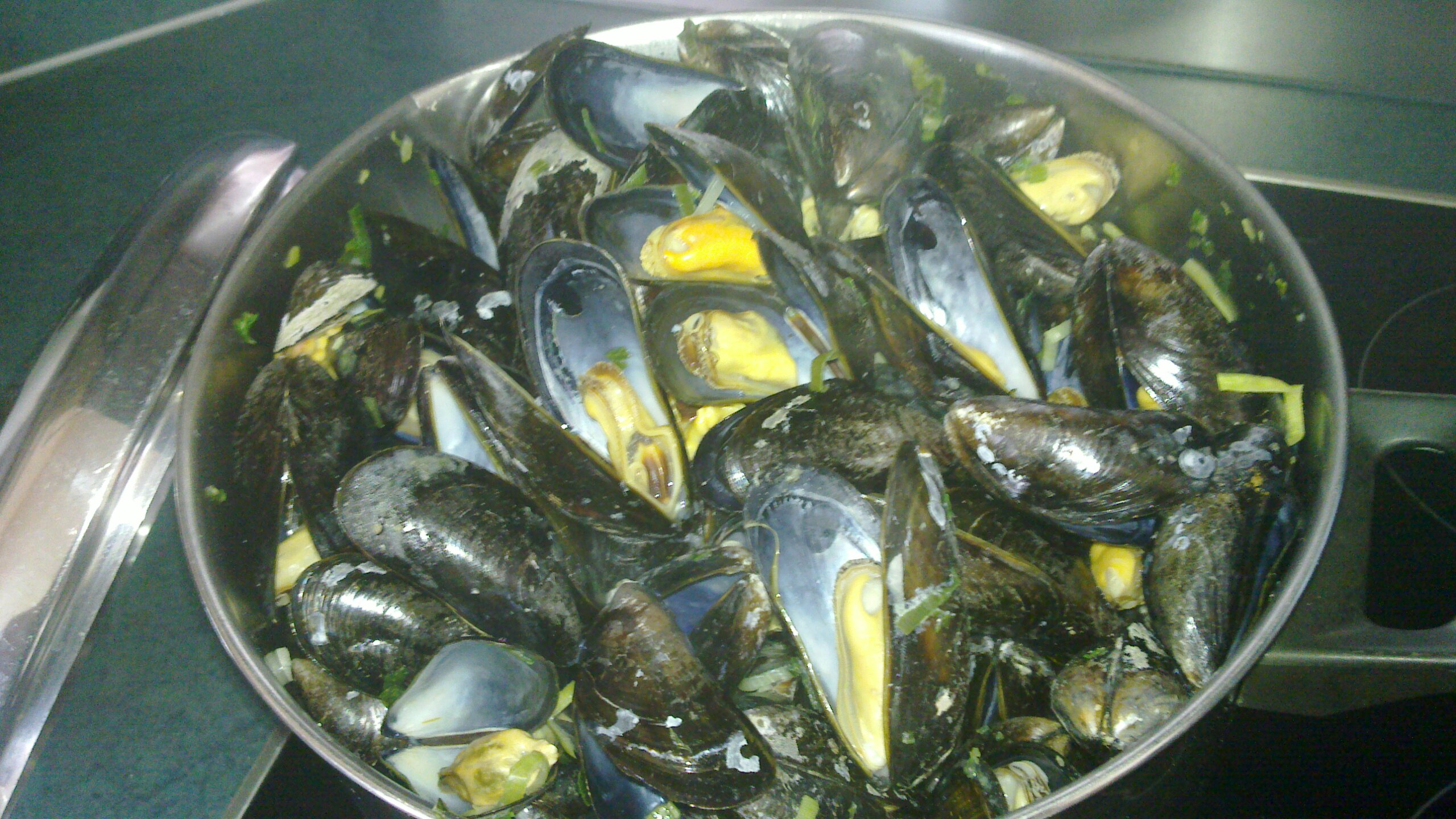 a pot filled with mussels and yellow slices