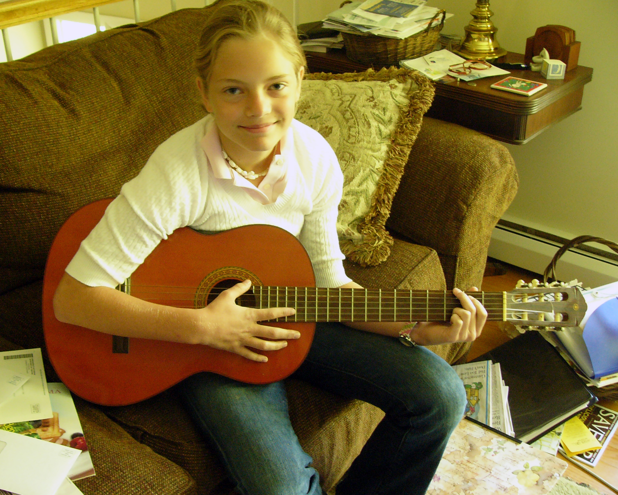 a girl is sitting on a couch holding a guitar