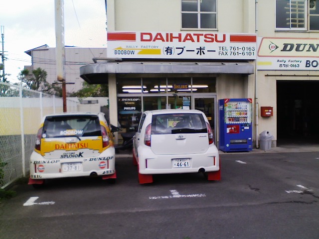 two cars parked in front of an asian business