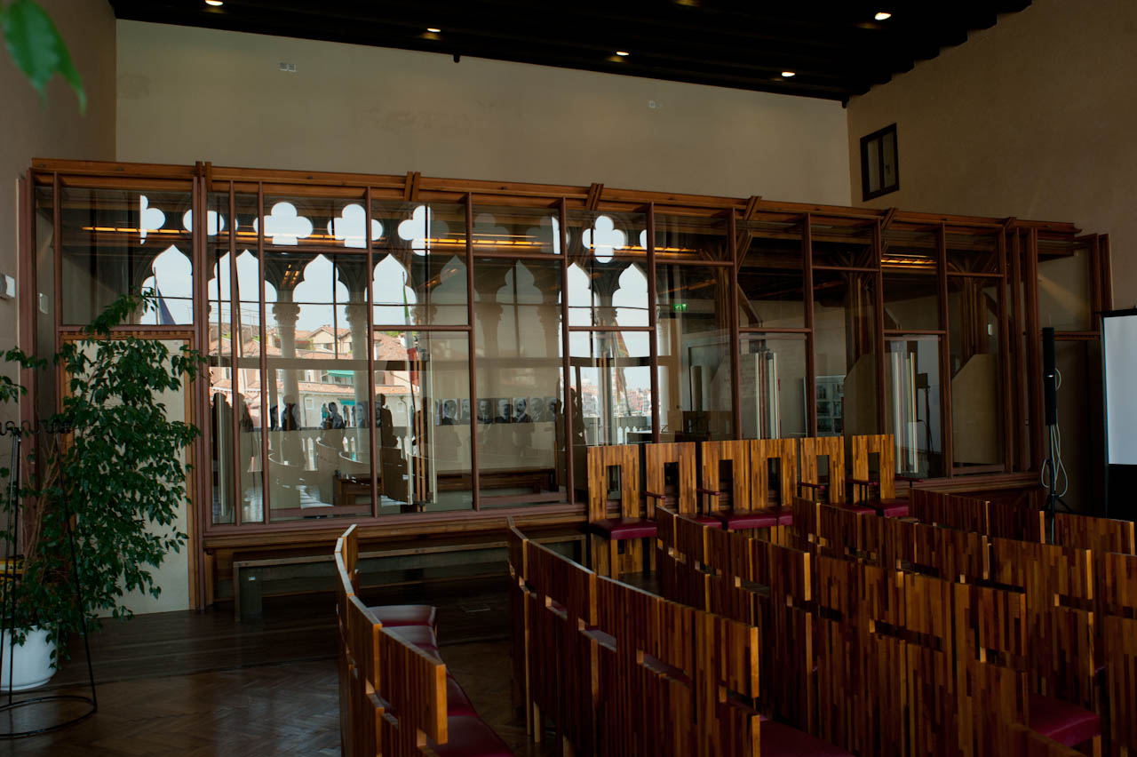 there is a church with wooden chairs and red chairs