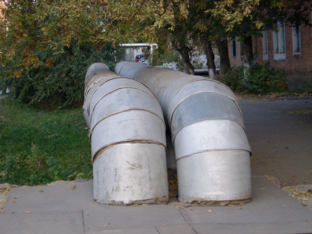 two large pipes are sitting on a sidewalk