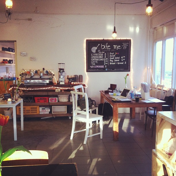 the interior of a restaurant that is decorated with white chairs