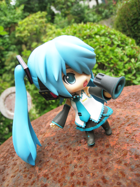 a small anime doll with blue hair and a long tail
