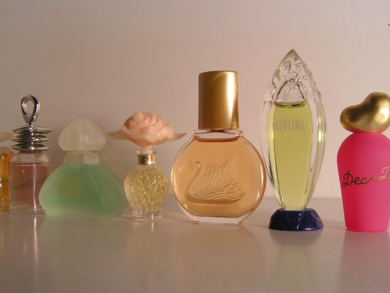 several perfume bottles lined up against a white wall