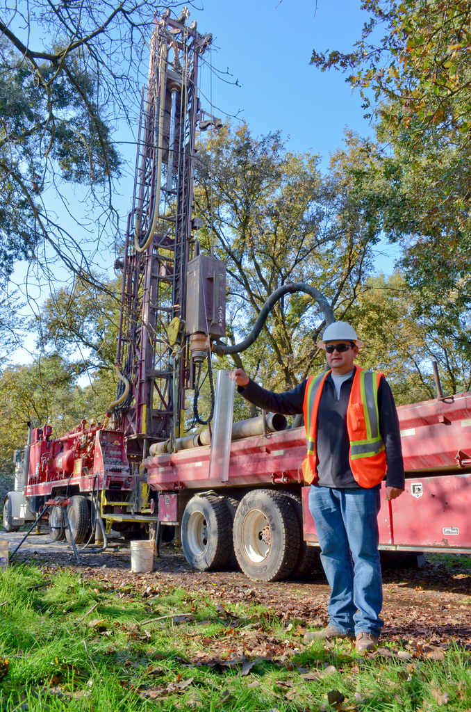 a man stands next to a large machine that is being built