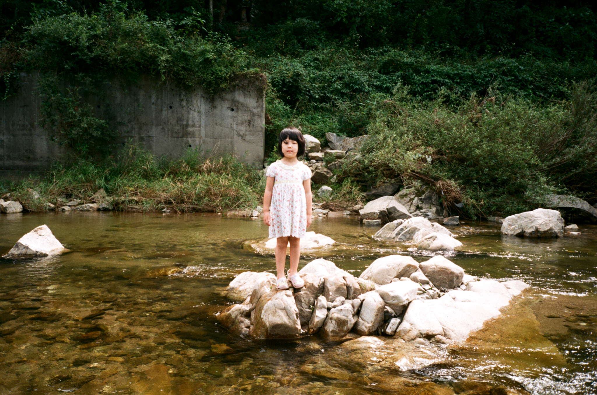 there is a  standing on rocks in the river