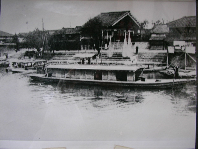 an old black and white po of a boat at a pier