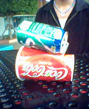 a woman sitting next to two cans of soda