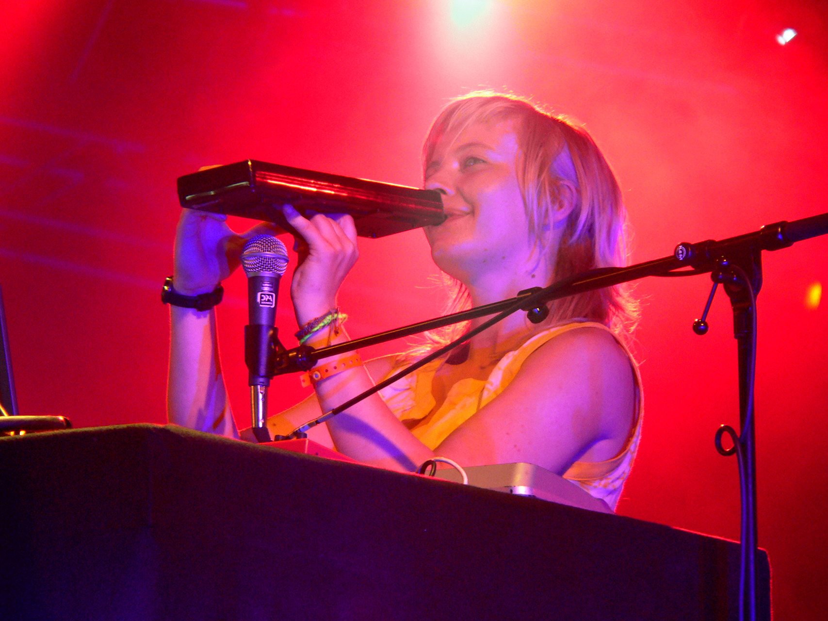 a woman in a white dress singing into a microphone