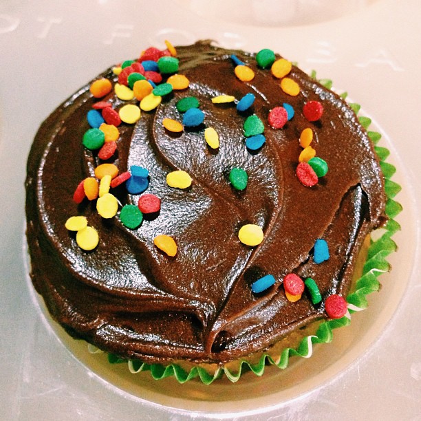 a close up of a cake with chocolate frosting and sprinkles