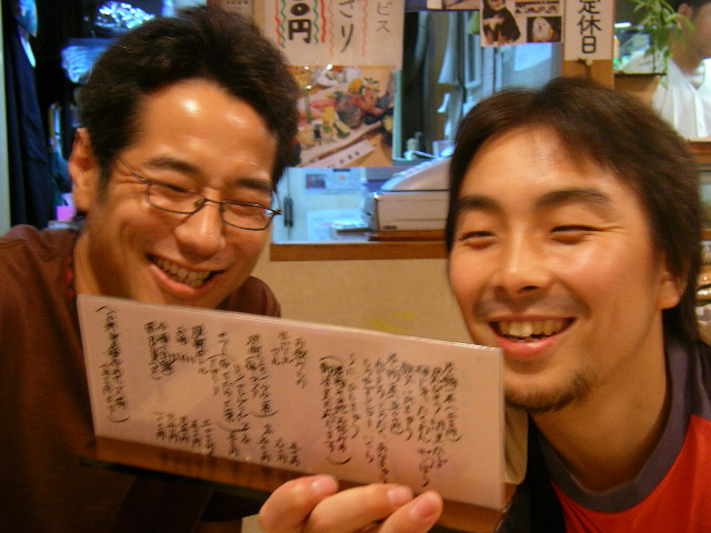 a couple of asian men holding up a piece of paper
