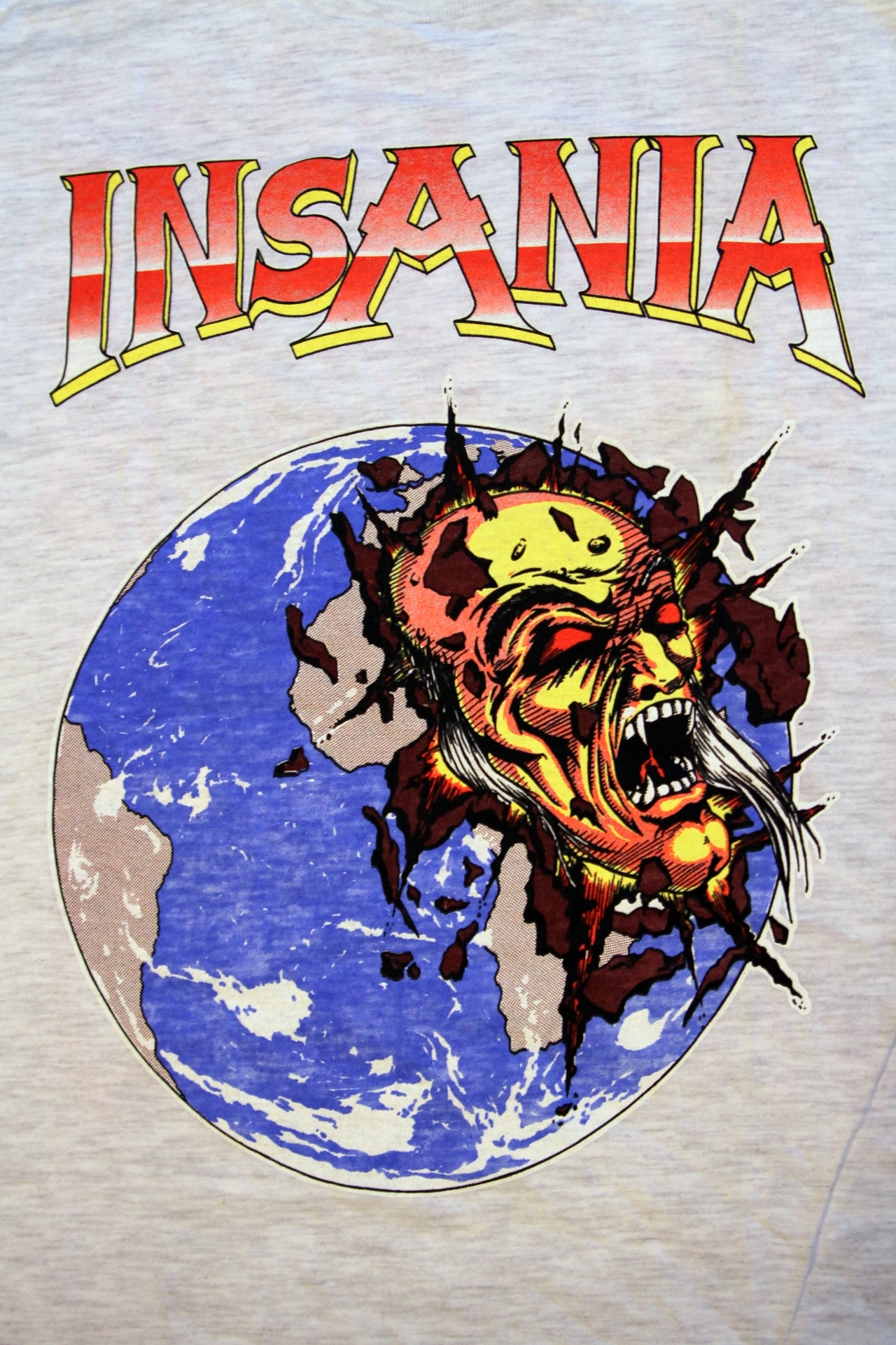 a white tee - shirt with a giant yellow head in front of a planet