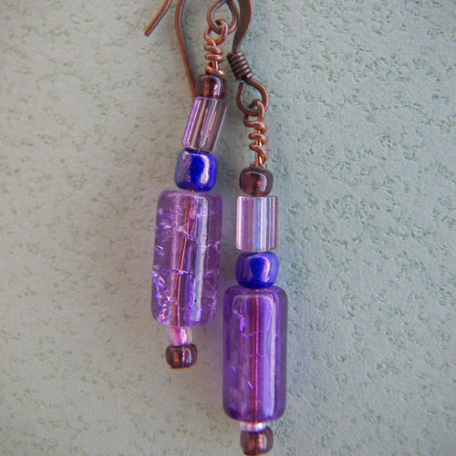 a couple of small purple beads hanging from some kind of hook - up earrings