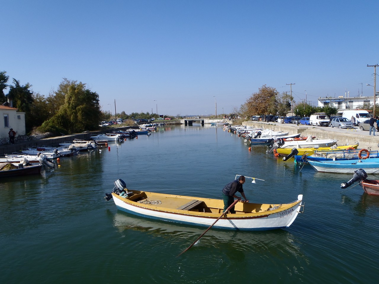 several boats sit in the water next to shore