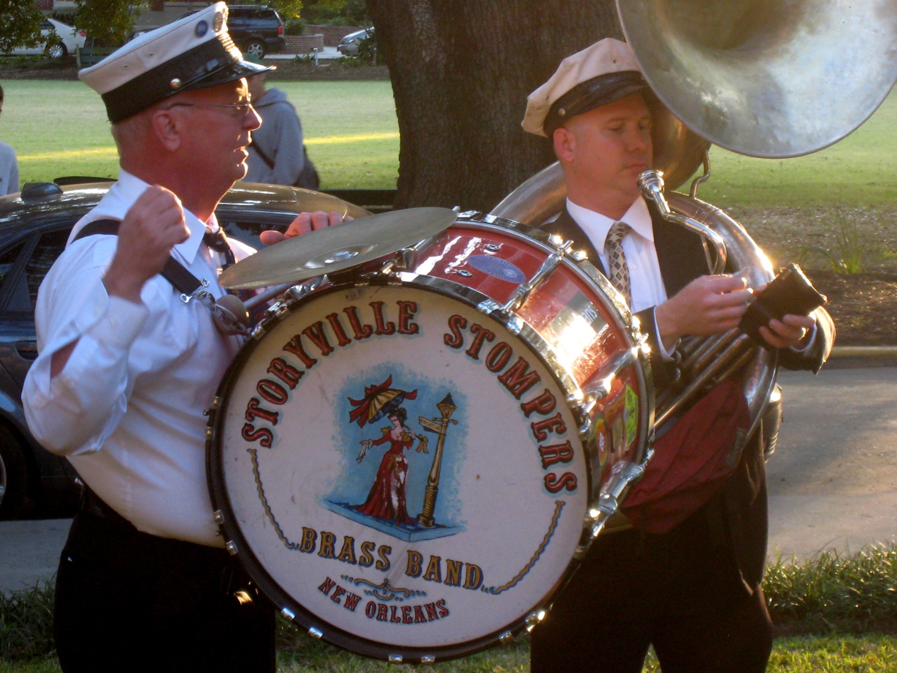 two men playing a large steel drum during a parade