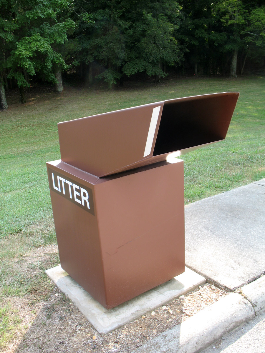 an open metal box on the sidewalk with the word litter displayed