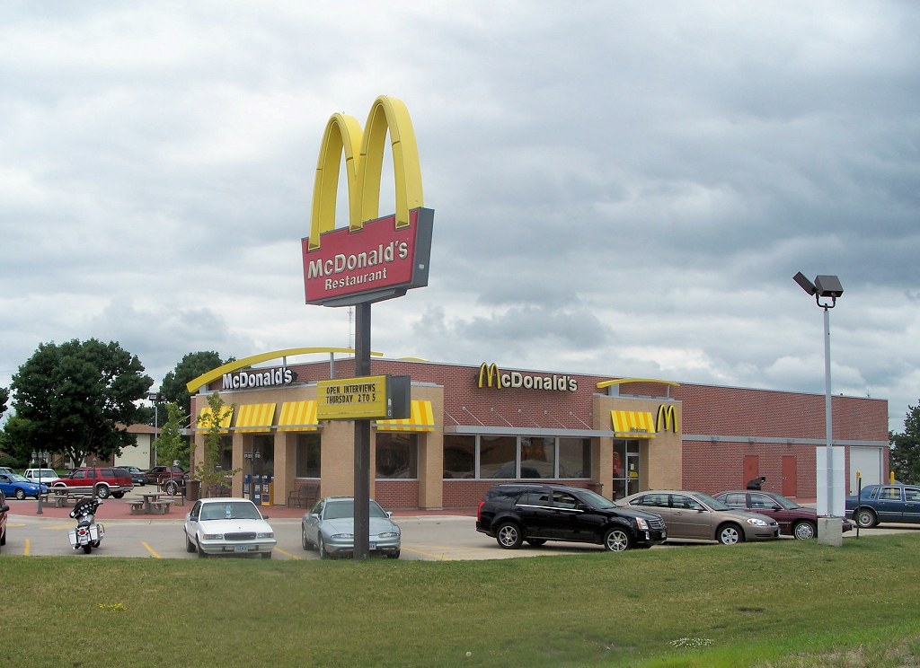 a mcdonalds sitting in a parking lot full of cars