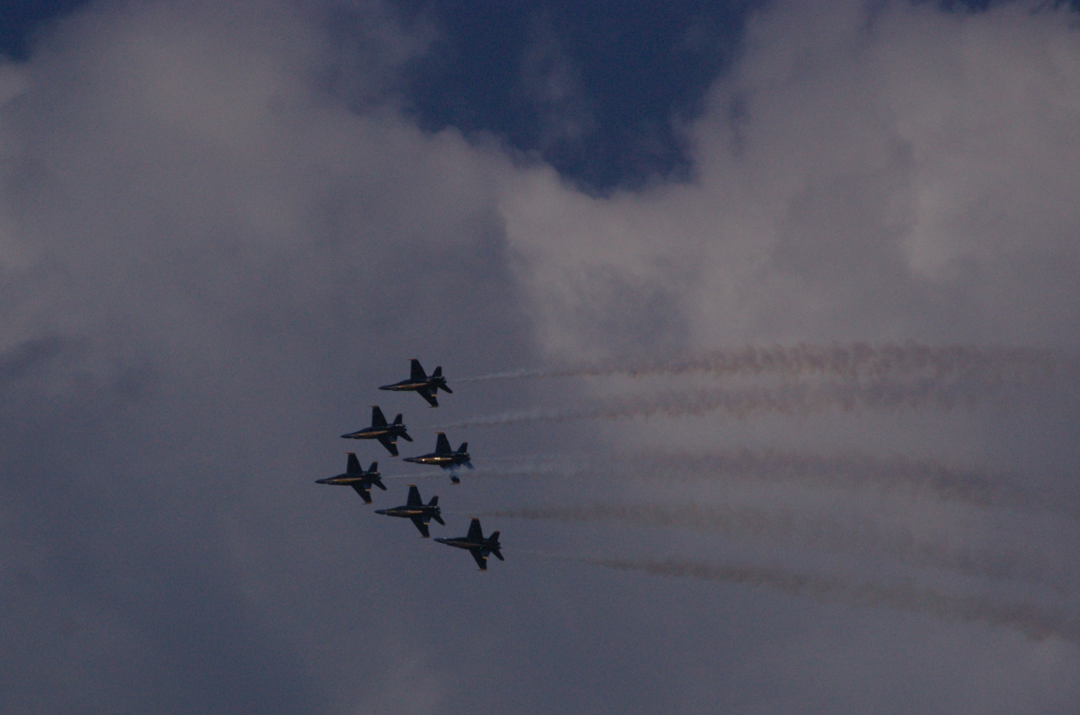 a group of fighter jets flying through a cloudy sky