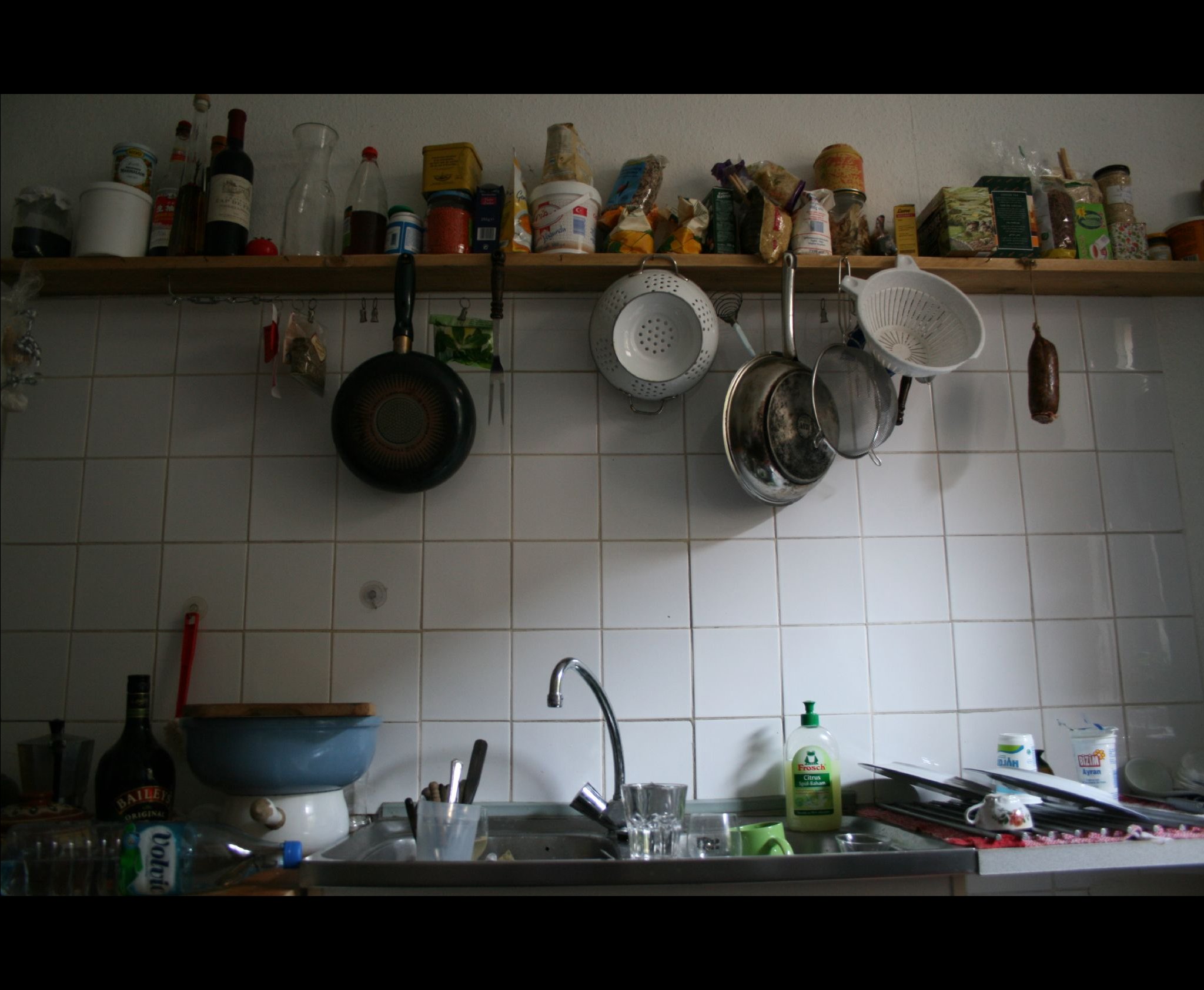 pots and pans hanging on a wall in a kitchen