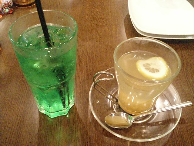 a cup of green tea with a lemon slice and a spoon