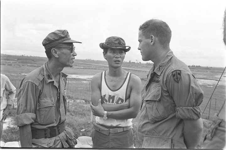 three men standing together in black and white