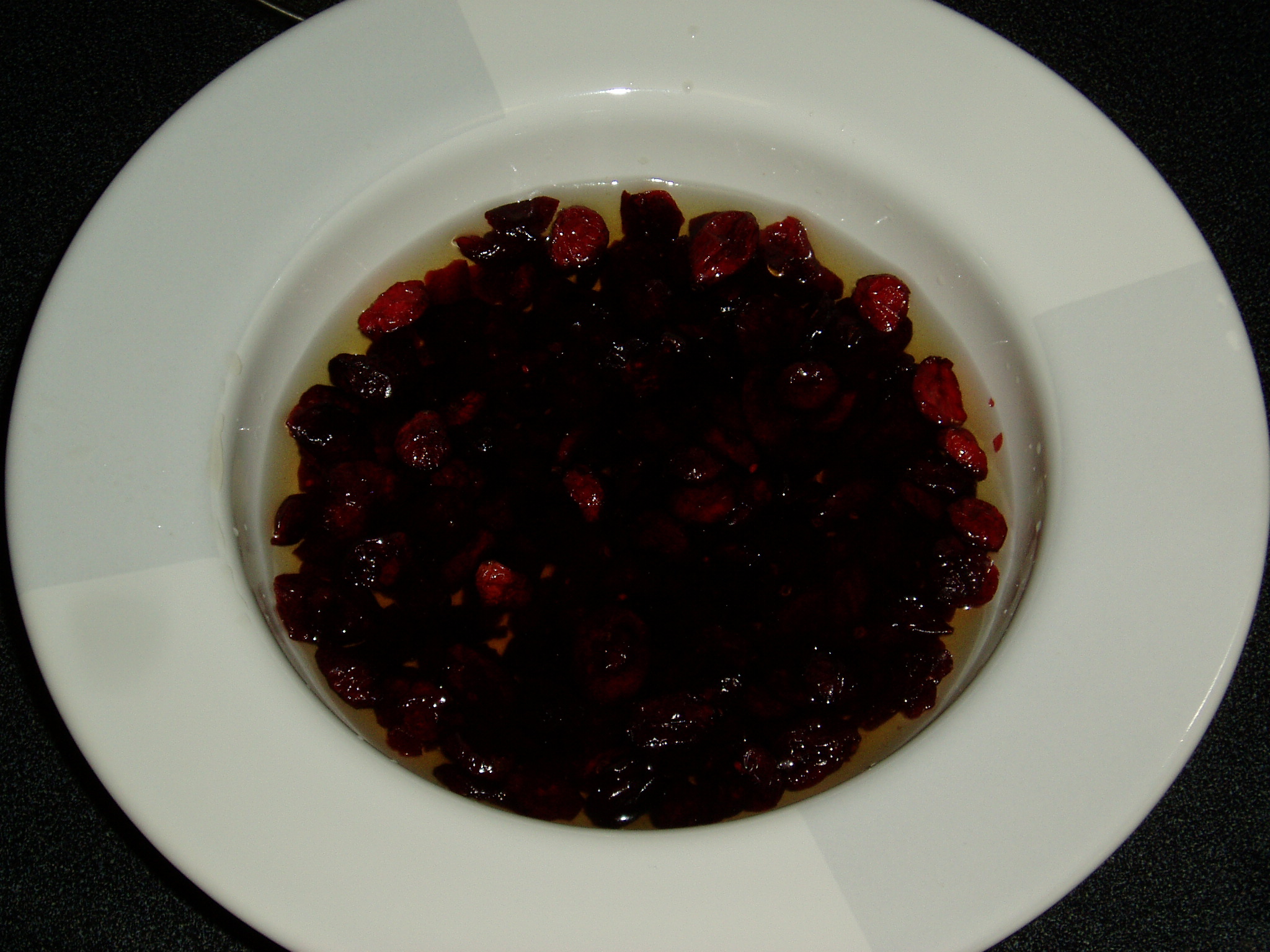 fruit with liquid in a white bowl on top of a counter