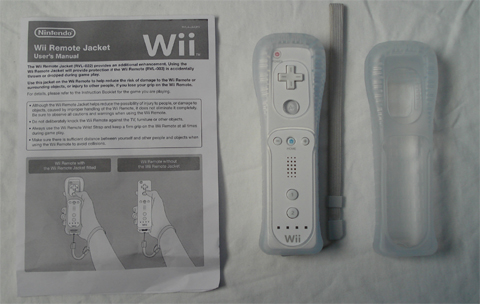 an nintendo wii remote next to a user manual