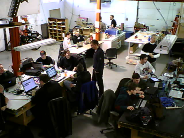 a bunch of people working in a room with many computers on it