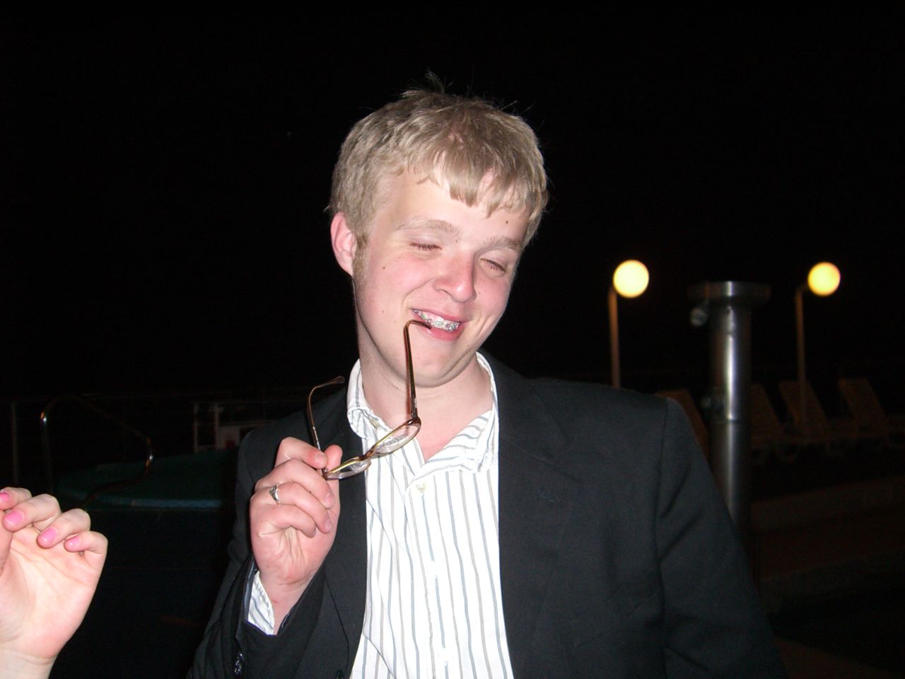 a man biting into soing while wearing a suit and tie