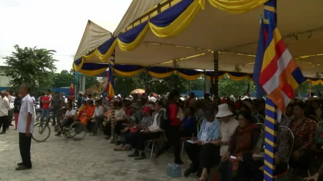 a crowd of people standing around in front of a tent