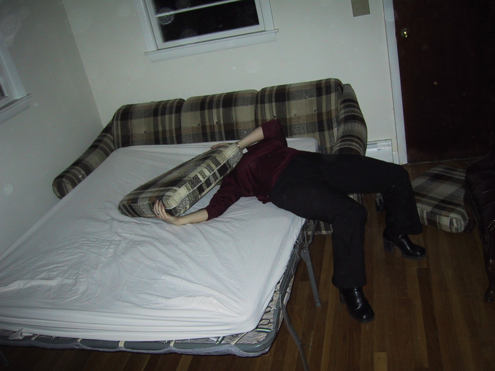 a person laying on top of a mattress next to a wall