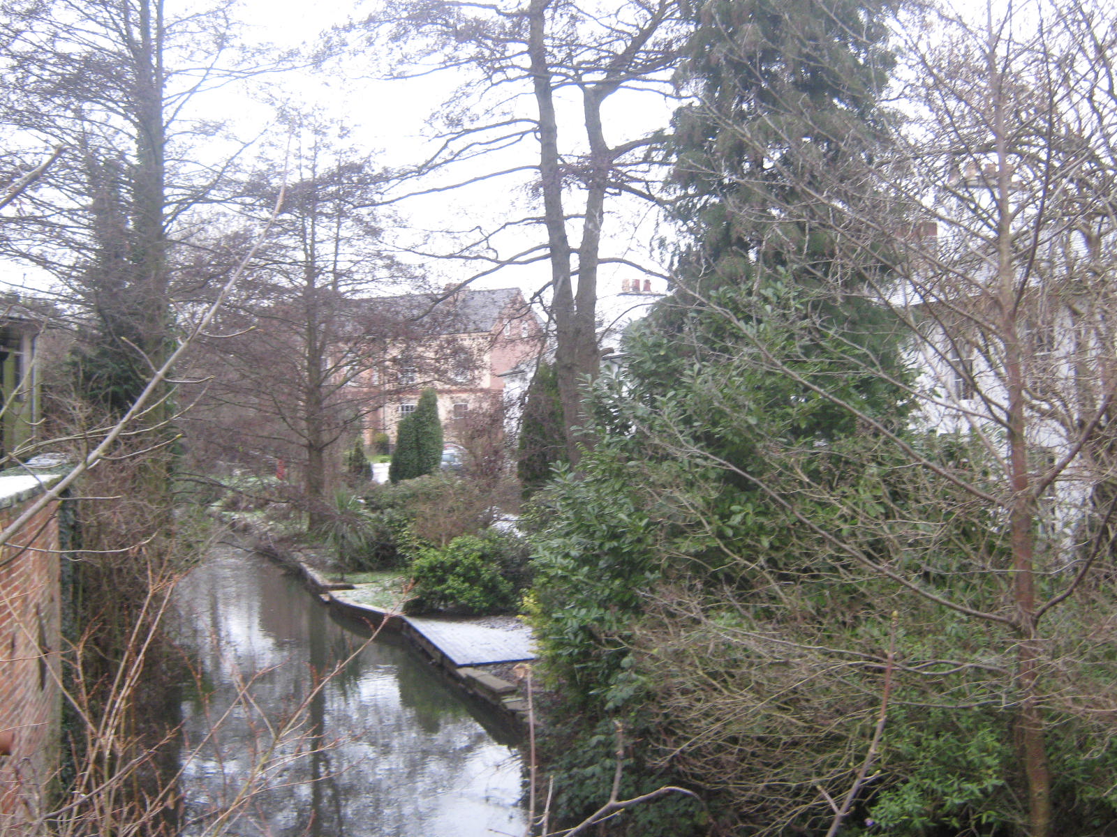 there is a canal that runs alongside trees and buildings