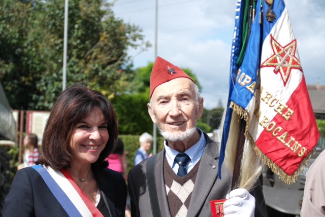 there is an elderly man and a woman that are holding flags