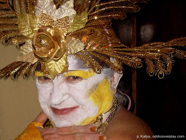 a woman with yellow hair and a mask that looks like feathers