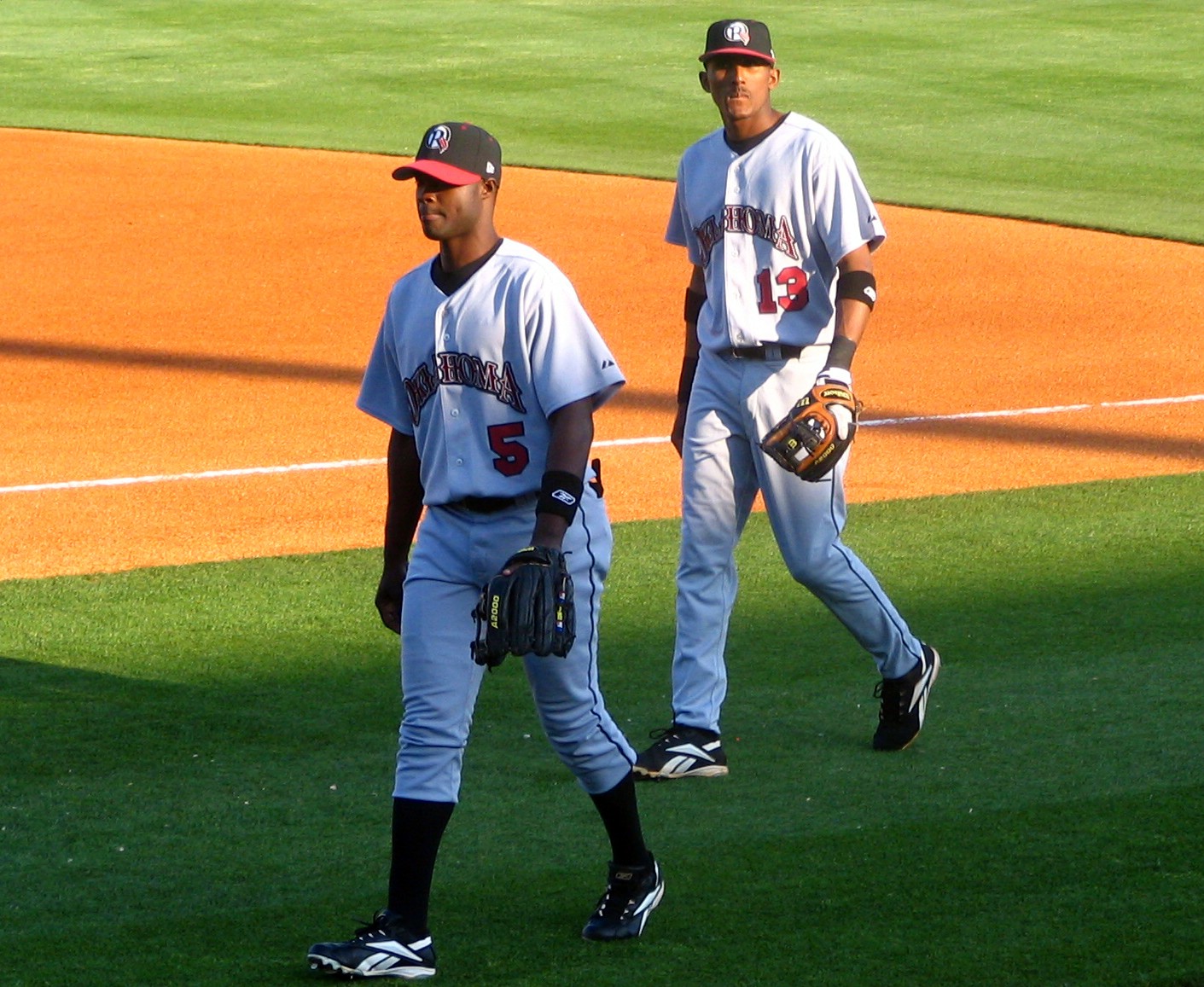 two baseball players walking away from the field