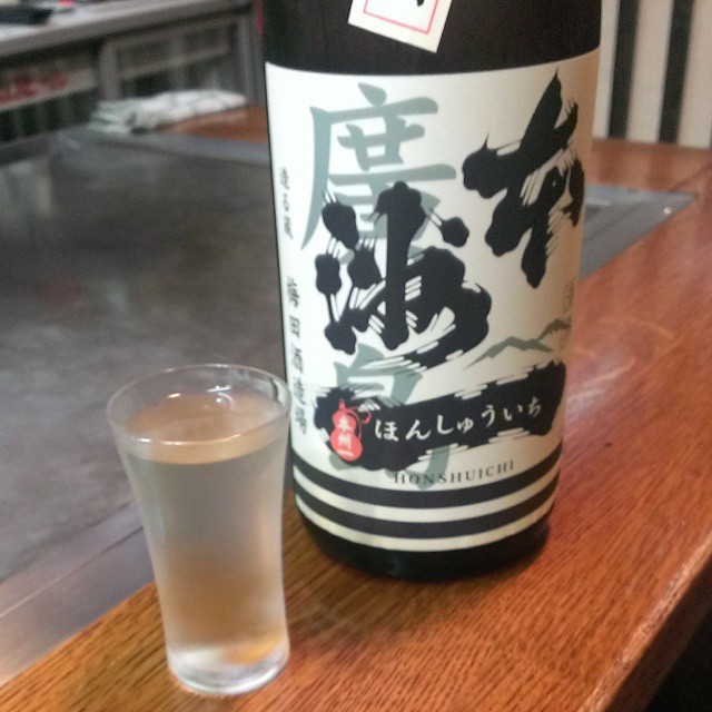 a bottle of sake next to a glass of water