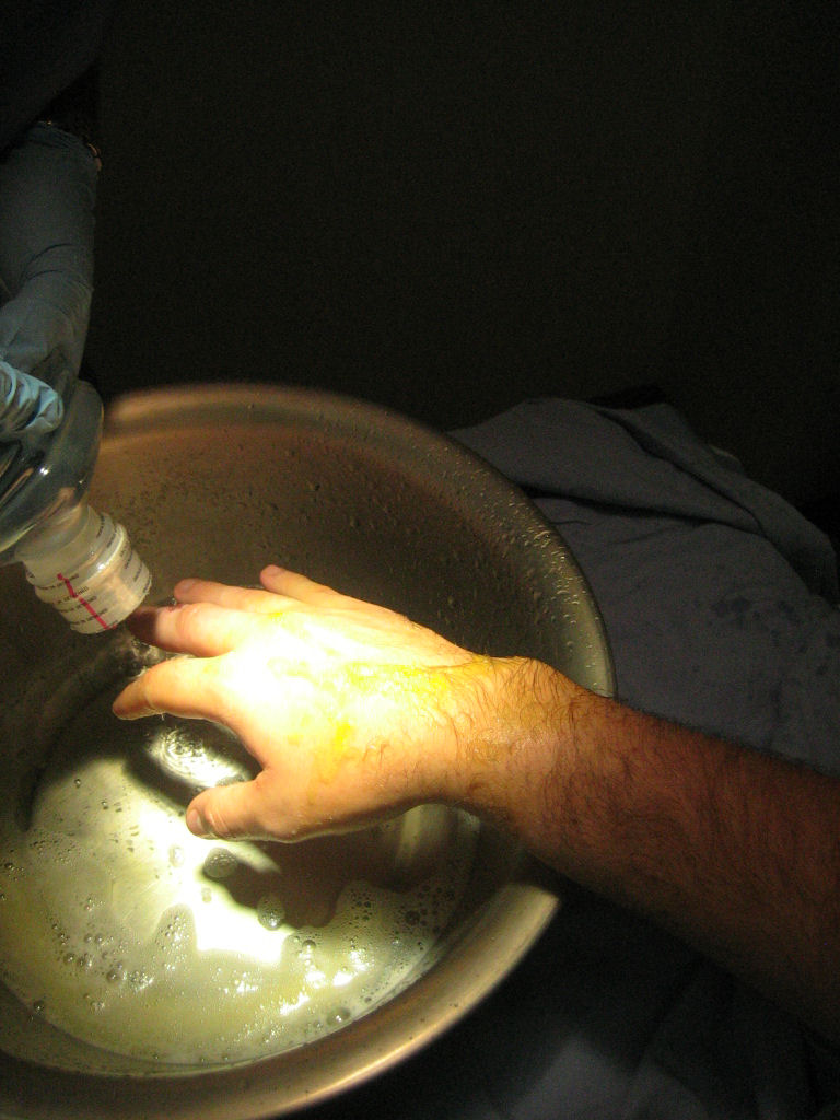 a person's hand reaching in to a pan with a liquid inside