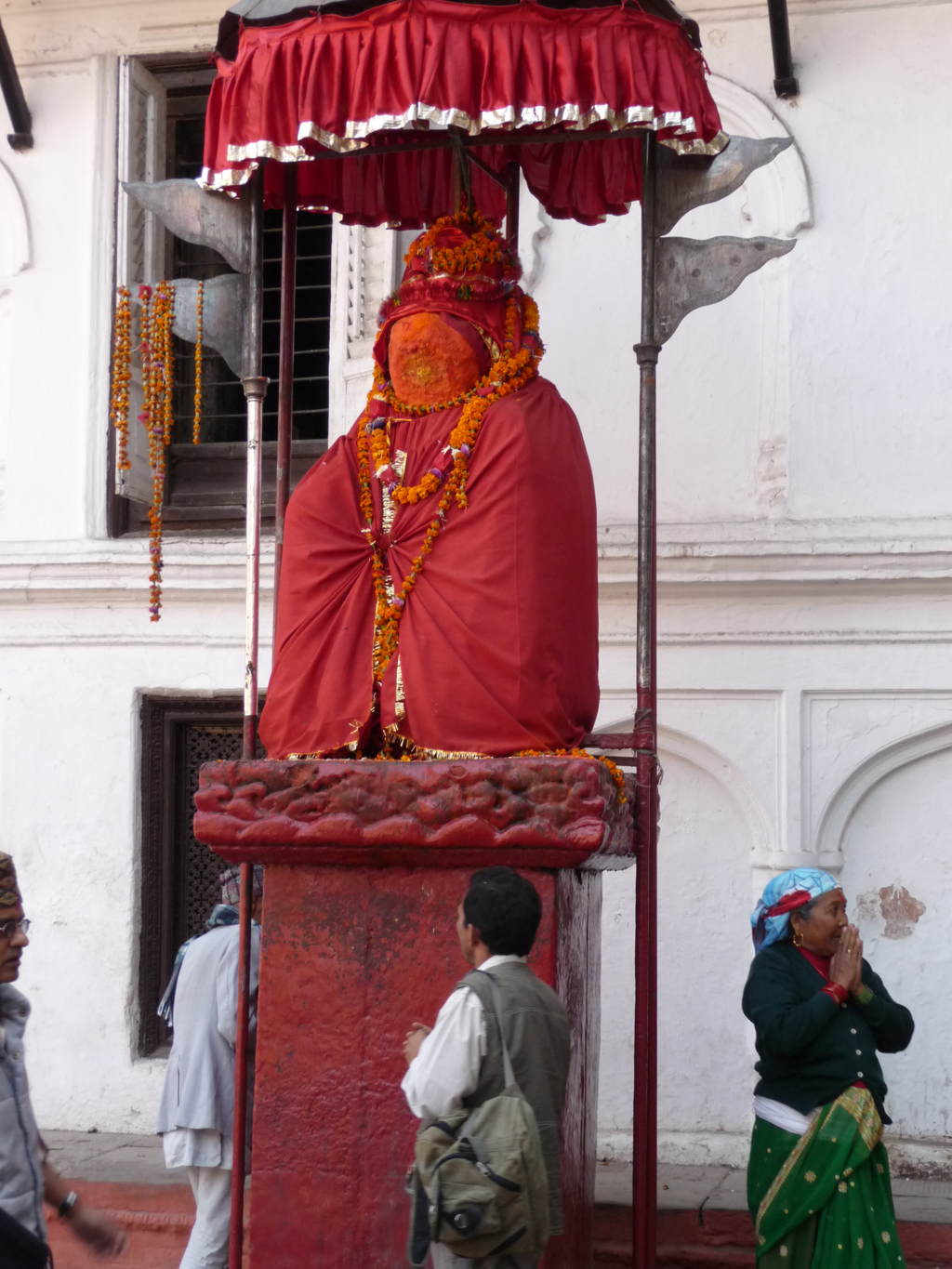 a giant statue with many decorations in front of a building