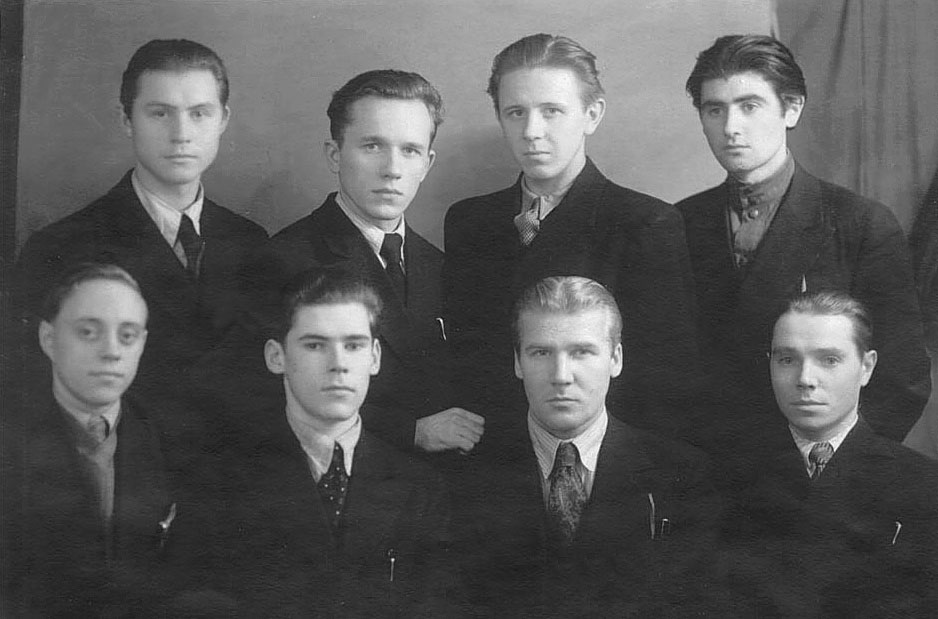 an old po of several people, with the men standing in front of them