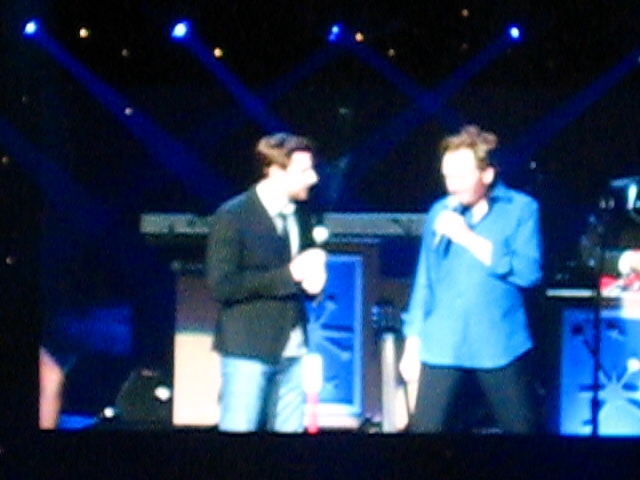 two men that are standing on a stage together
