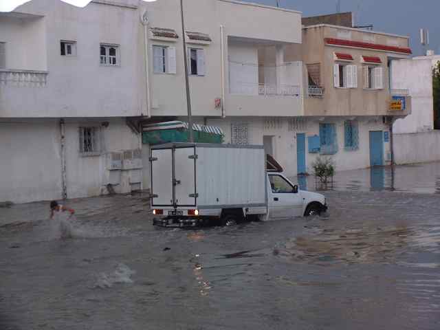 a flooded street with trucks parked on top of it