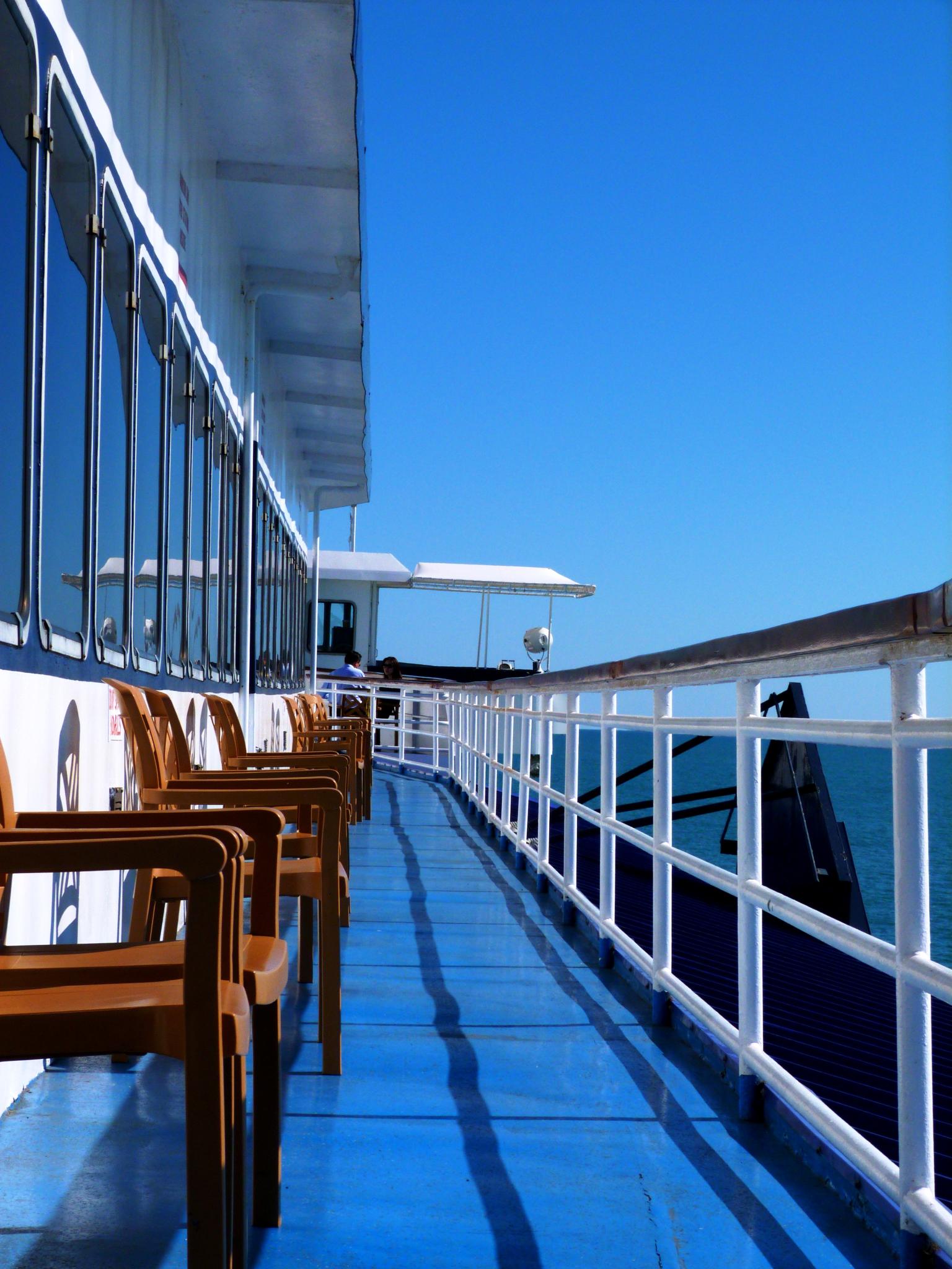 the sun shines brightly on a blue cruise ship deck