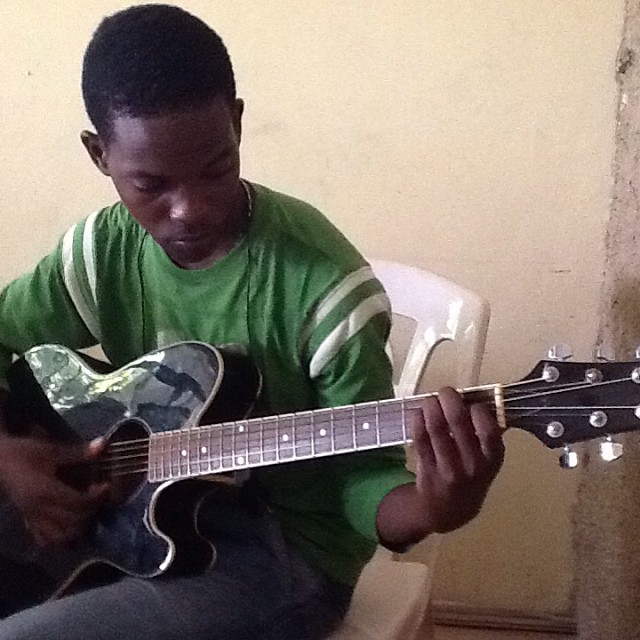 the young man is playing a guitar and posing for a po