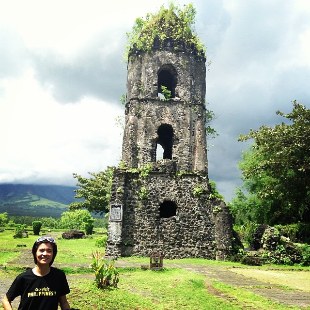 a man is standing by a small old tower