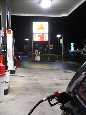 gas pump at night with car going by