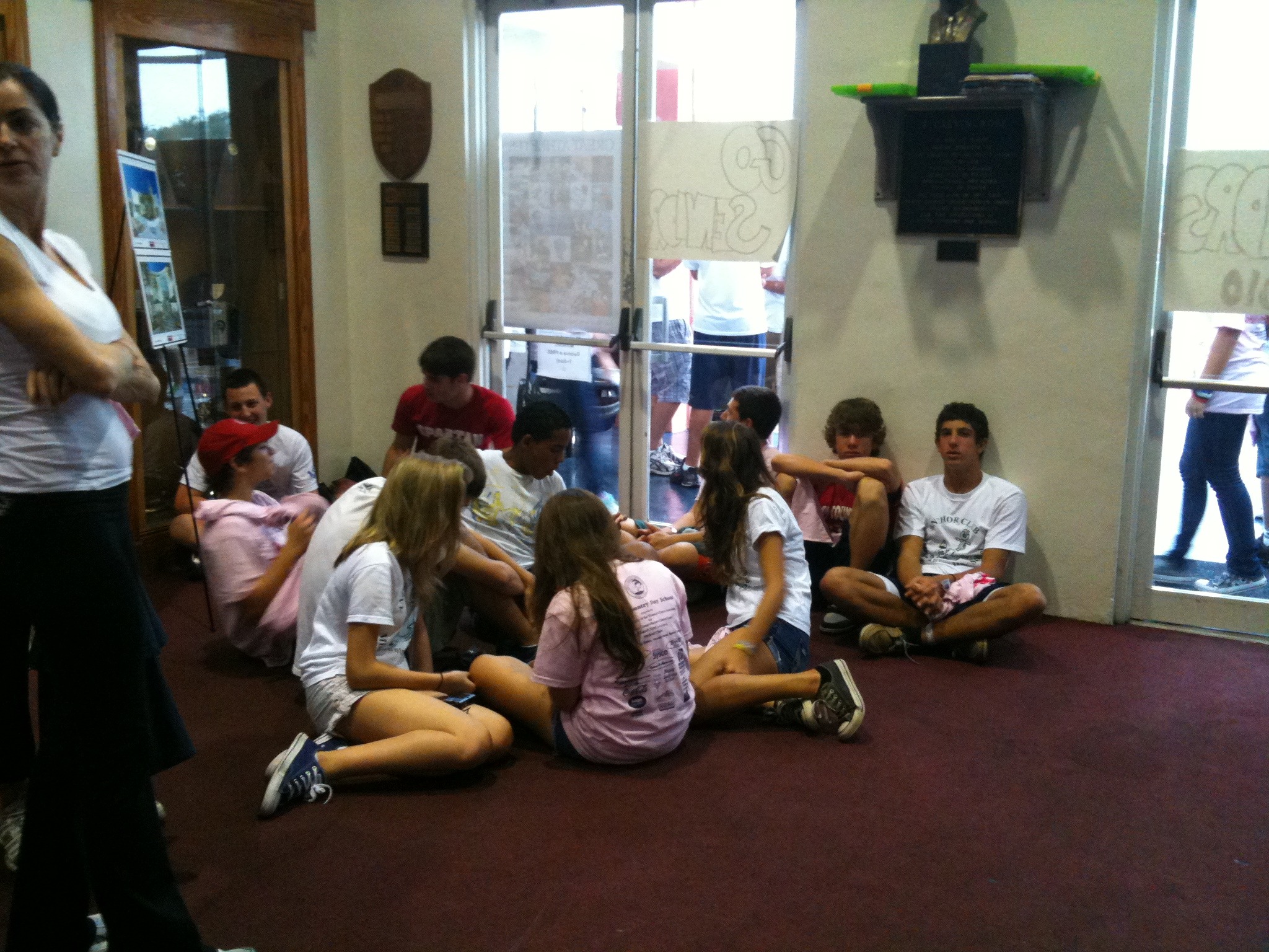 a group of young people sitting on the floor of a house