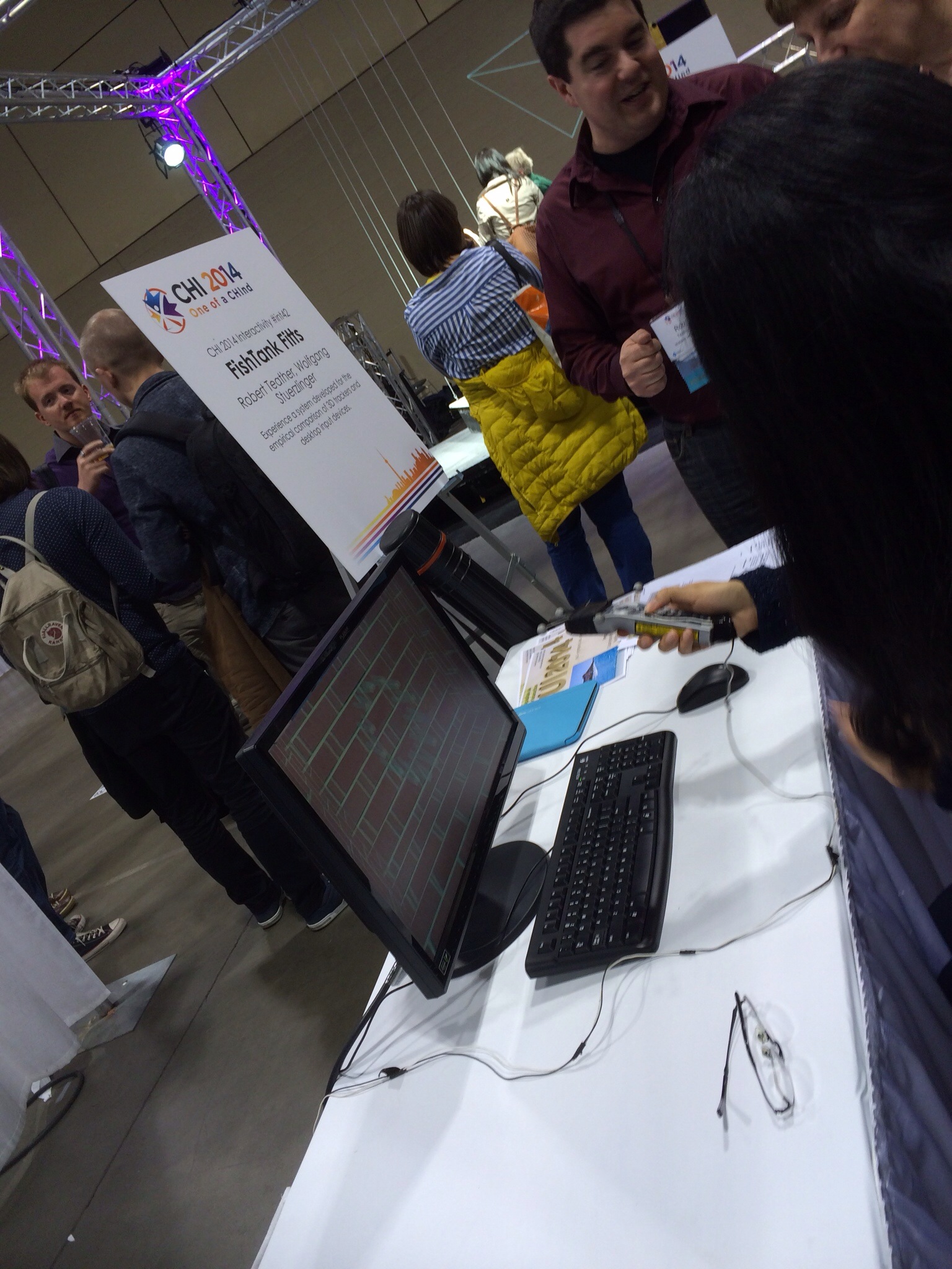 man standing by a laptop computer with a mouse in his hand