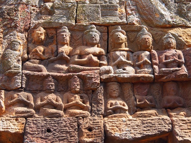 a wall made with carvings of buddhas on it