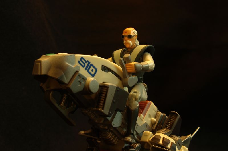 a toy robot riding a vehicle with a helmet on