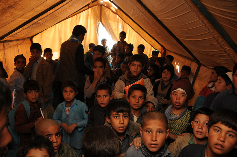 a number of children in a tent with one person looking down